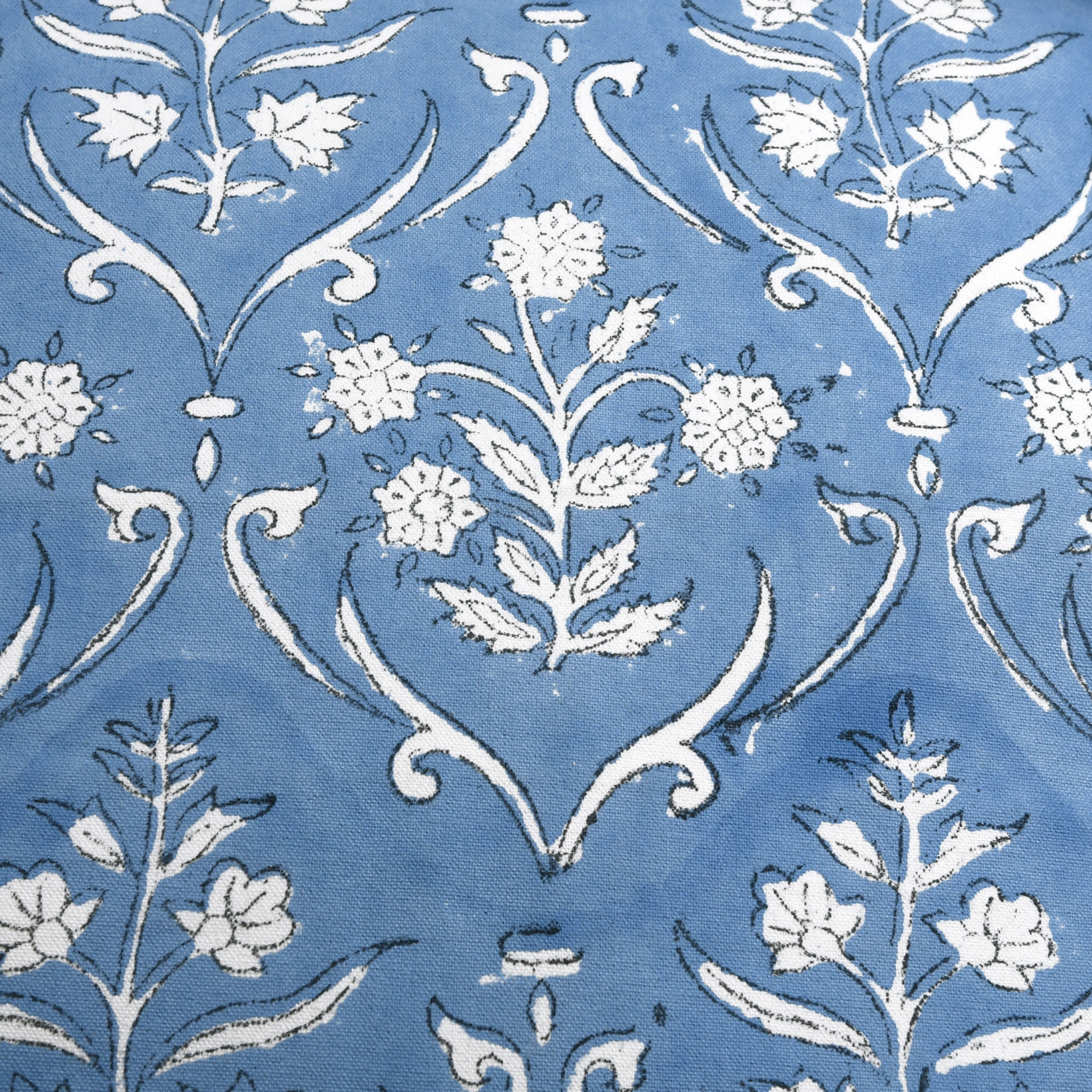 Decorative fabric pattern with white flowers and leaves on a blue background