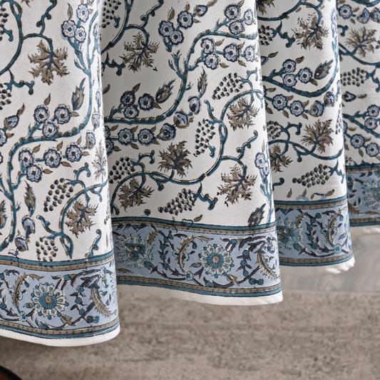 Close-up of patterned fabric with floral and vine designs on a neutral background