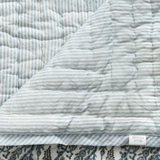 Quilted fabric with blue and white stripes on a floral background