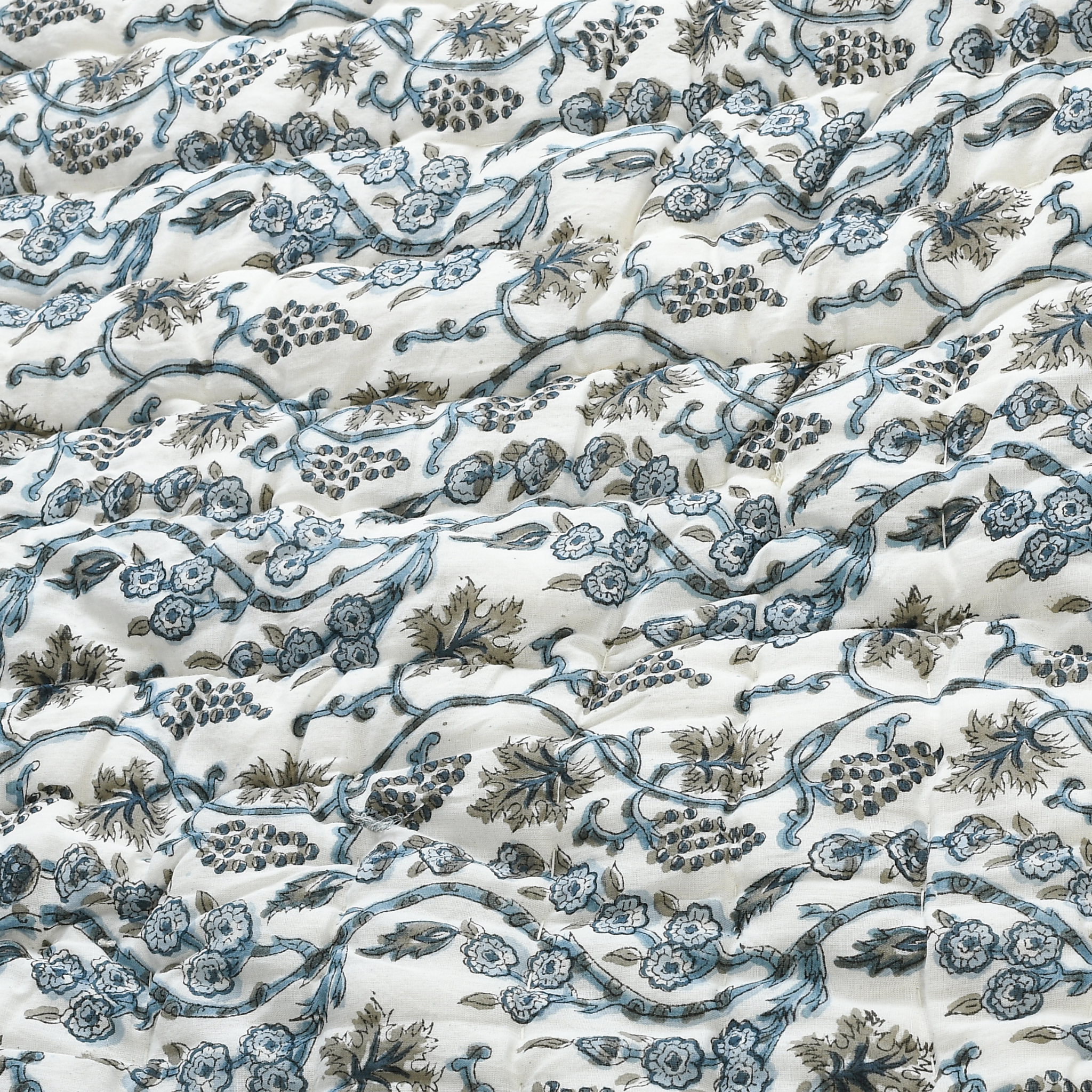 Floral and vine patterned fabric in blue and green on a white background