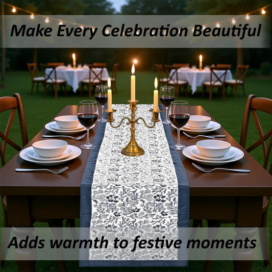 Dining table set for a celebration with candles, wine glasses, and a decorative table runner.