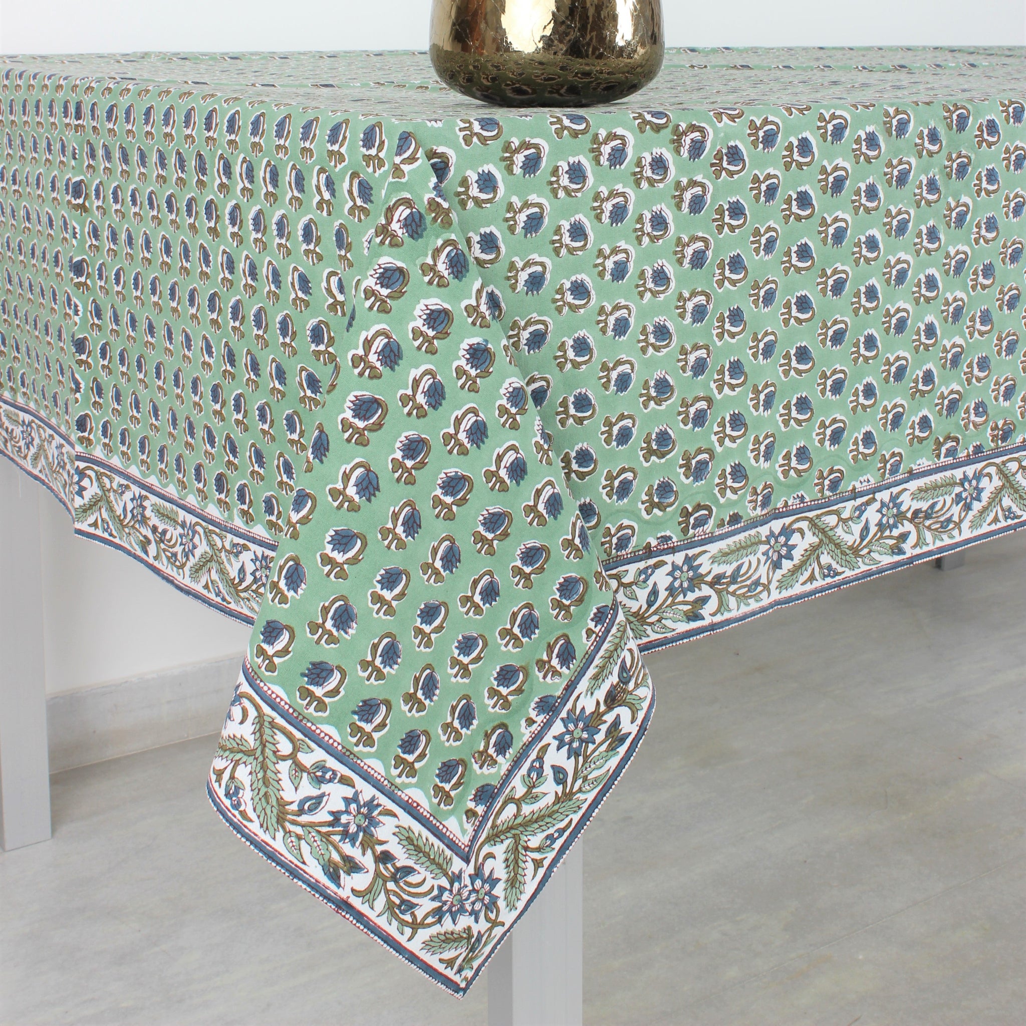 Tablecloth with floral pattern and flowers in a vase on a white background