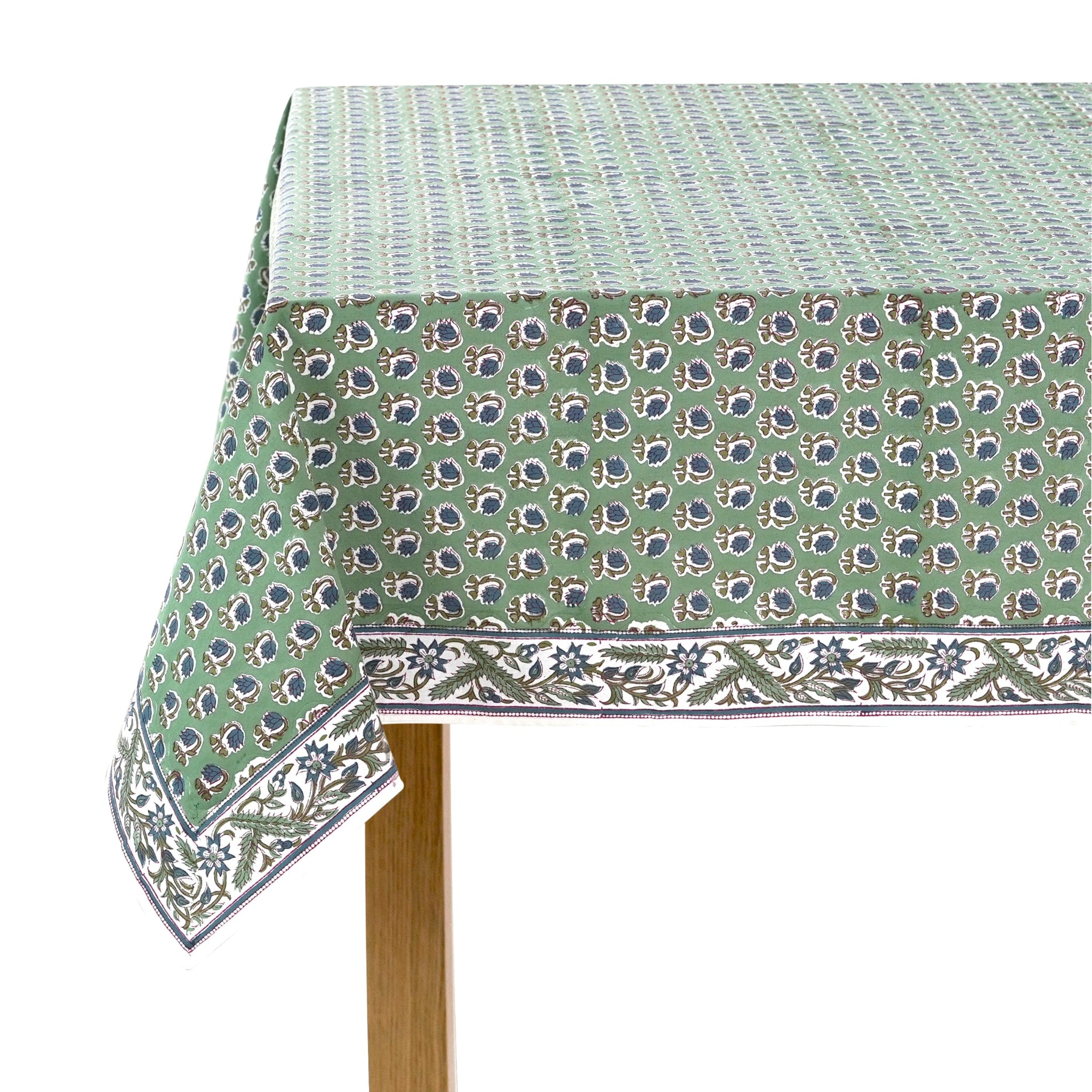 Green floral patterned tablecloth on a wooden table