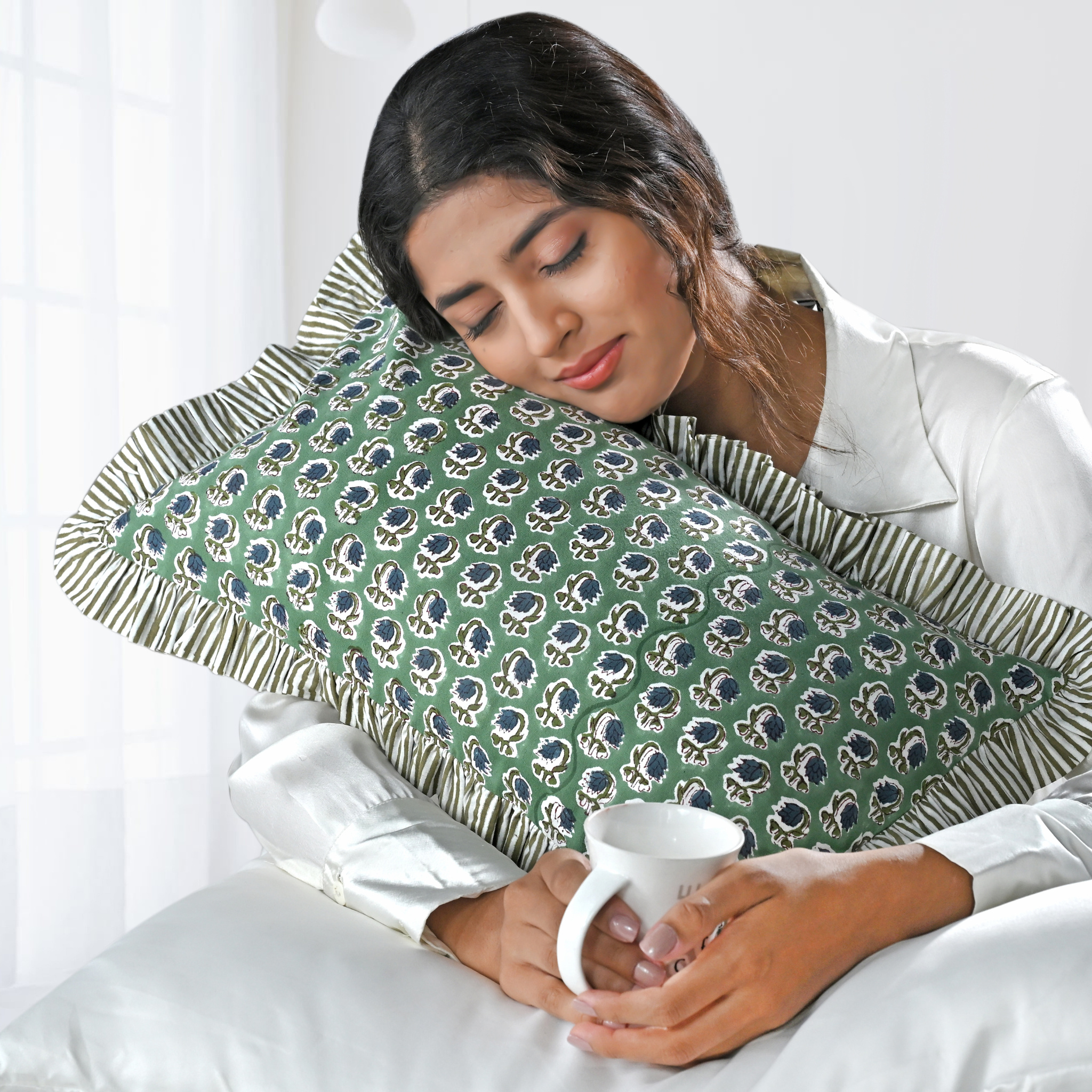Woman holding a mug with a green patterned pillow on her back