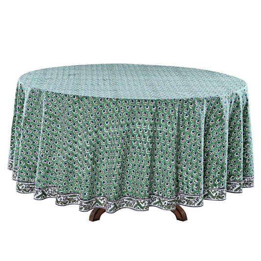 Round table with a green patterned tablecloth on a white background