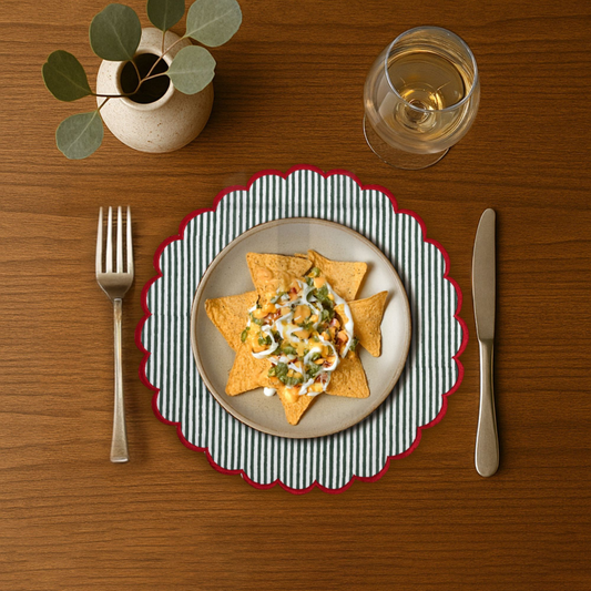 Dinner setting with a plate of food, fork, knife, and glass on a wooden table.