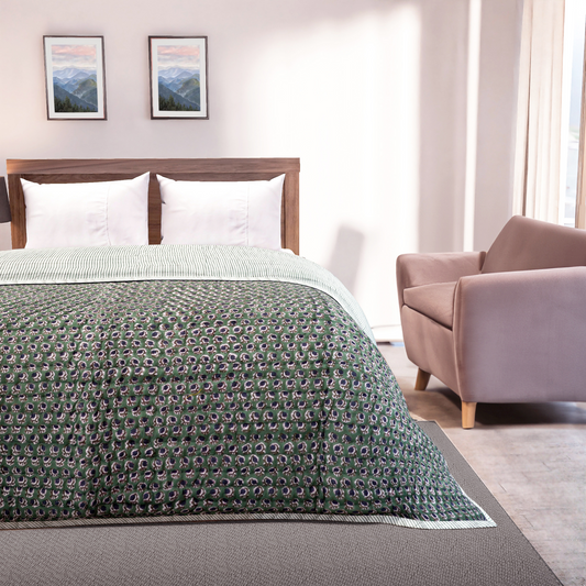 Bedroom with a bed covered in a green patterned comforter, a wooden headboard, and a pink armchair.