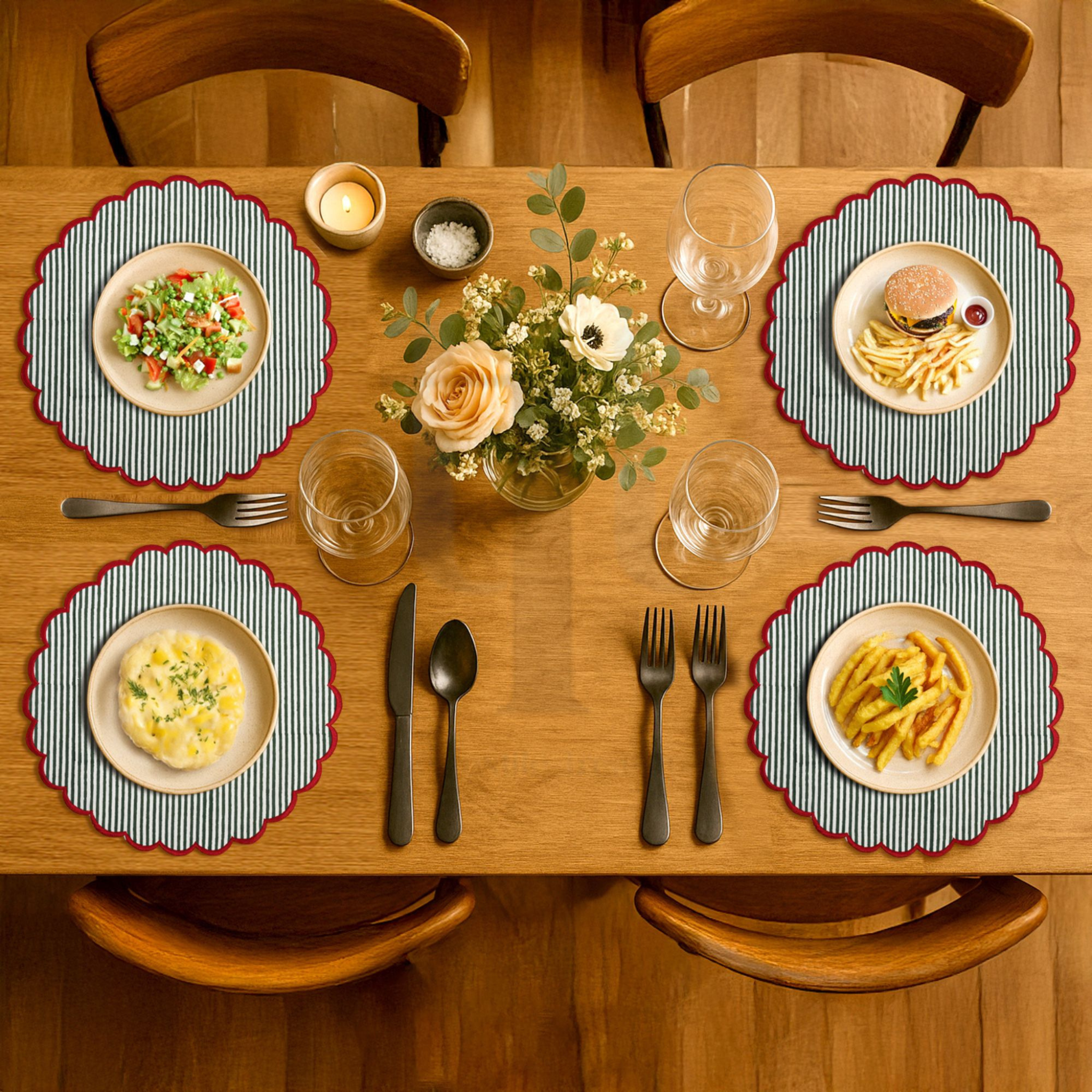 Dining table set with plates of food, glasses, and cutlery on a wooden table.