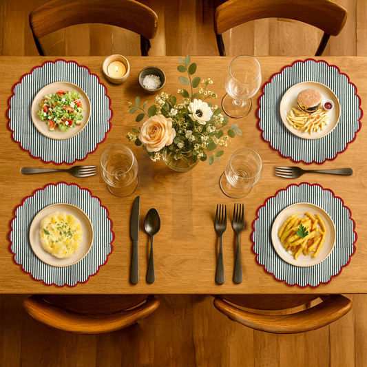 Dining table set with plates of food, glasses, and cutlery on a wooden table.