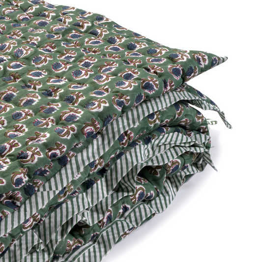 Green fabric with a pattern of blue and white shapes on a white background