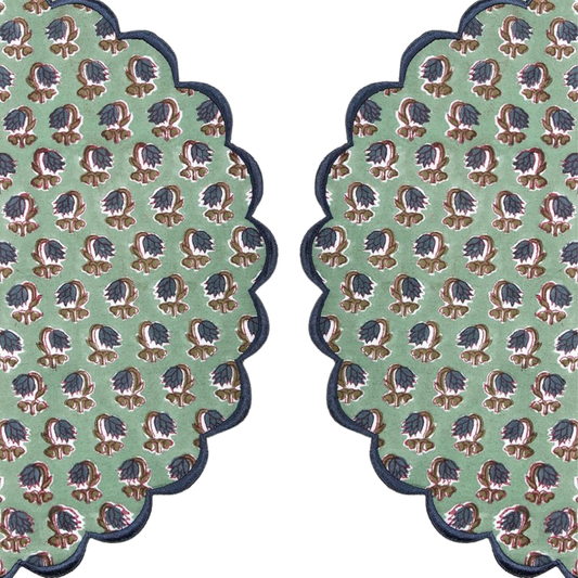 Two green patterned coasters with scalloped edges on a white background