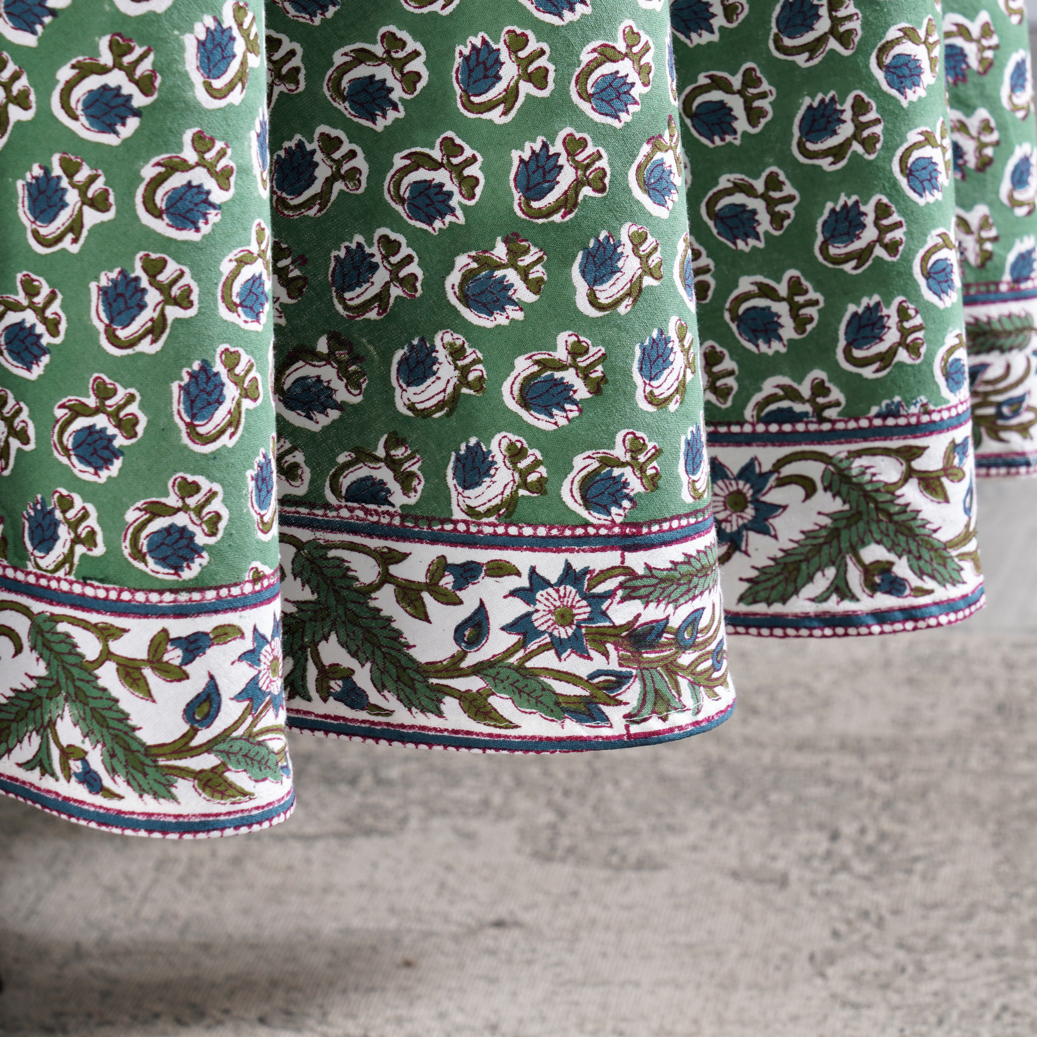 Close-up of green fabric with floral pattern on a textured surface