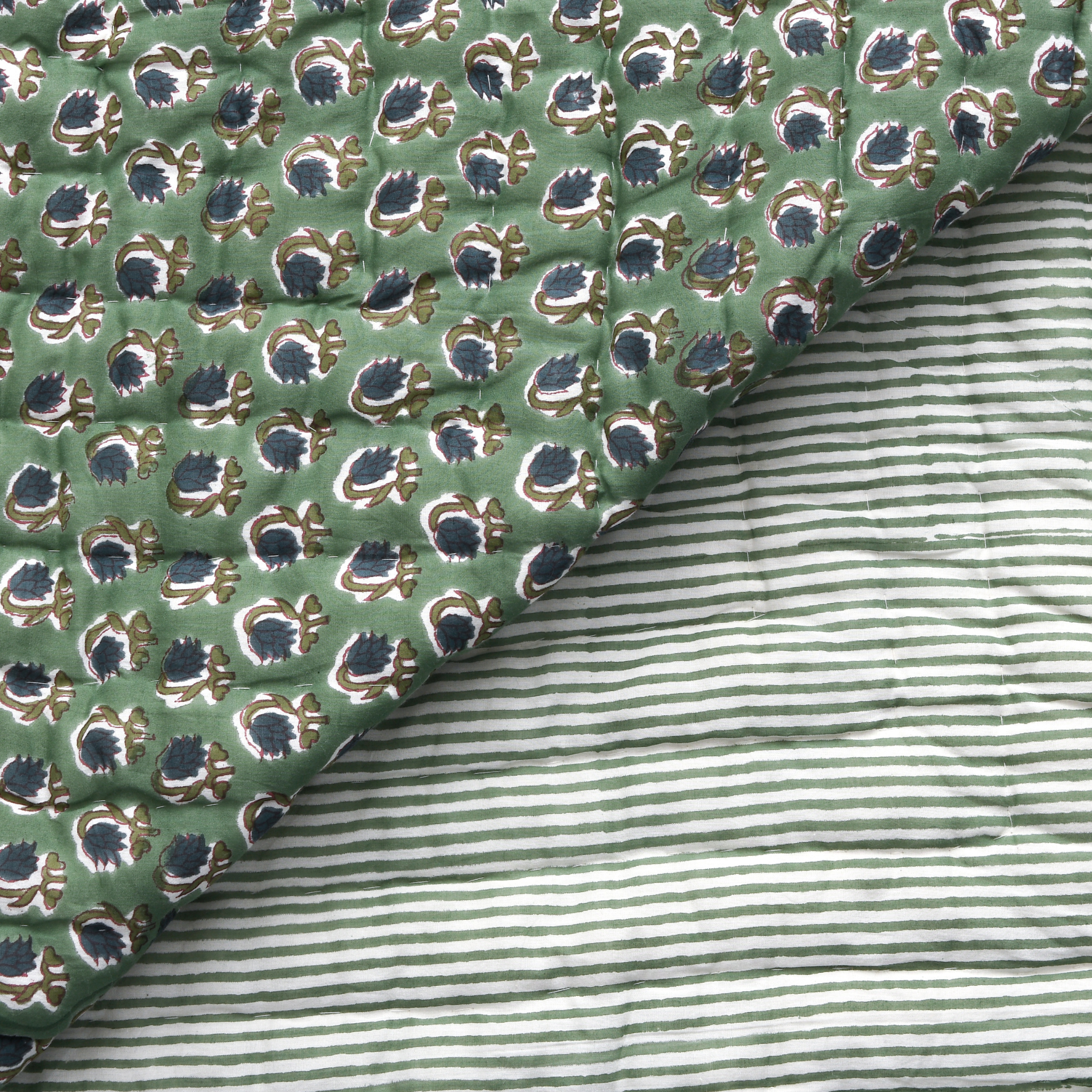 Close-up of green patterned fabric with a striped fabric underneath