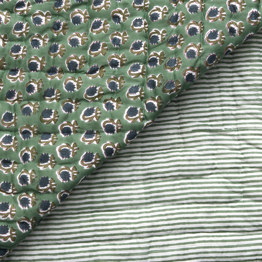 Close-up of green patterned fabric with a striped fabric underneath