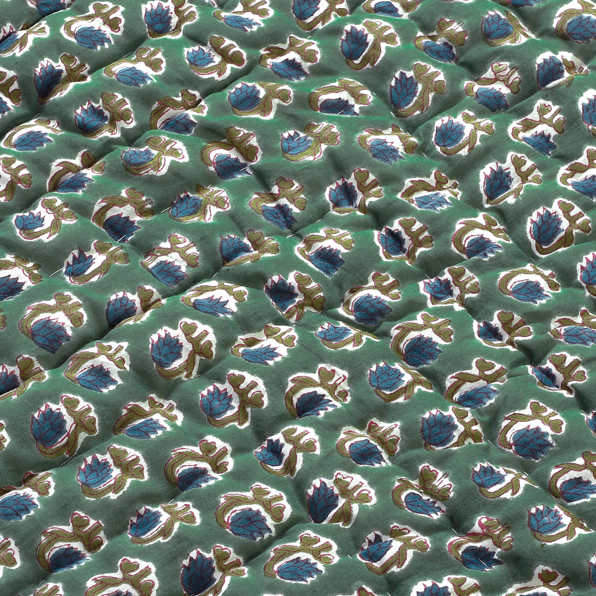 Close-up of a patterned fabric with blue and gold designs on a green background