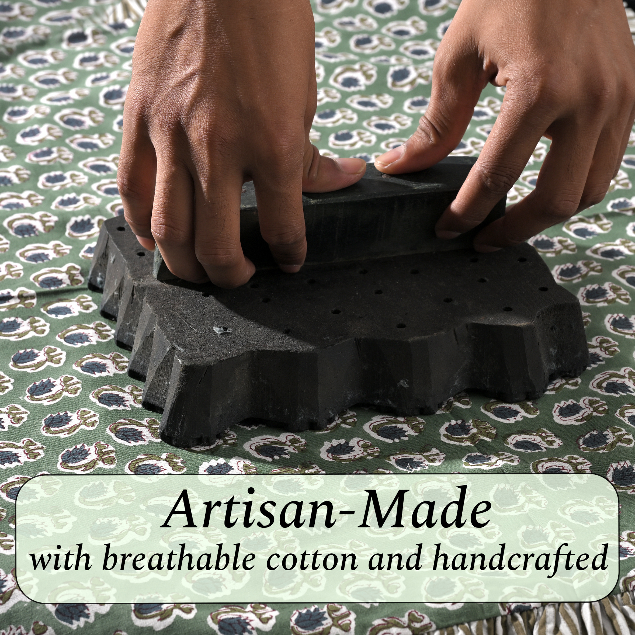 Hands using a black textured block on a patterned fabric background with 'Artisan-Made' text.