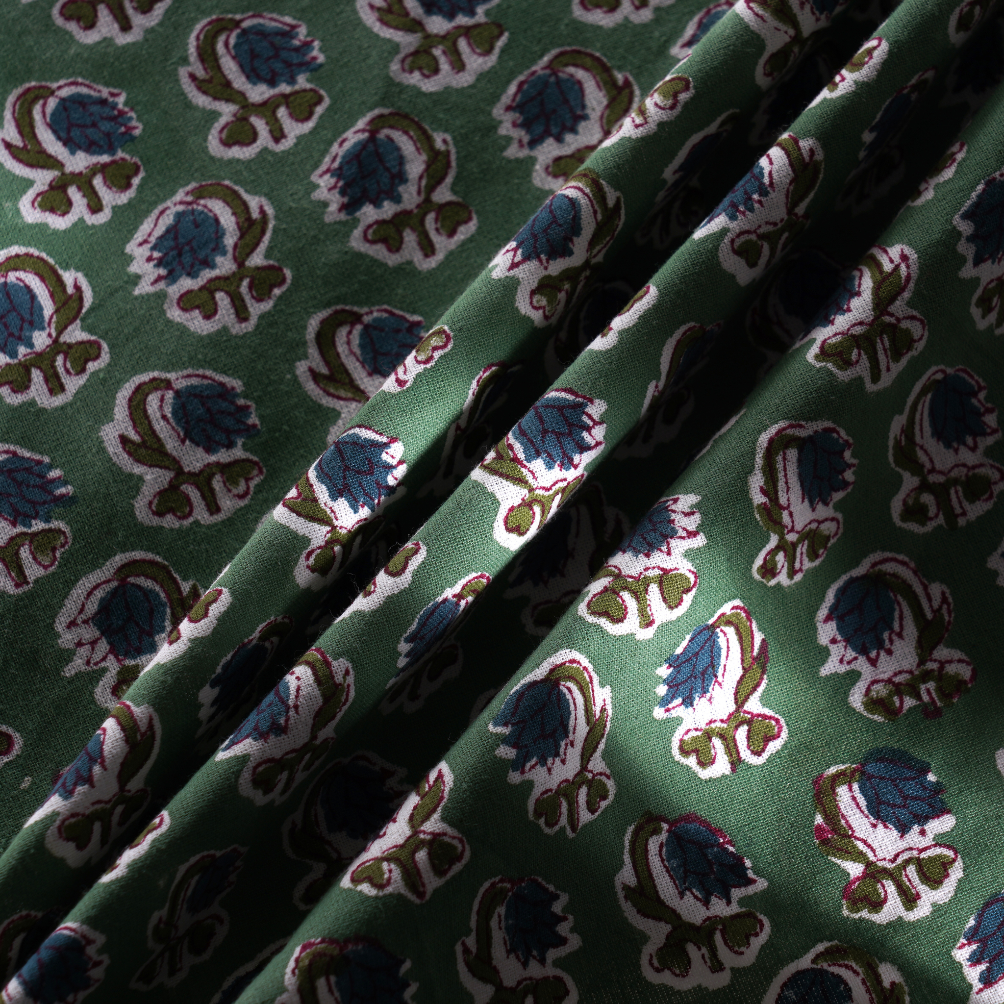 Green fabric with a pattern of blue and brown floral designs
