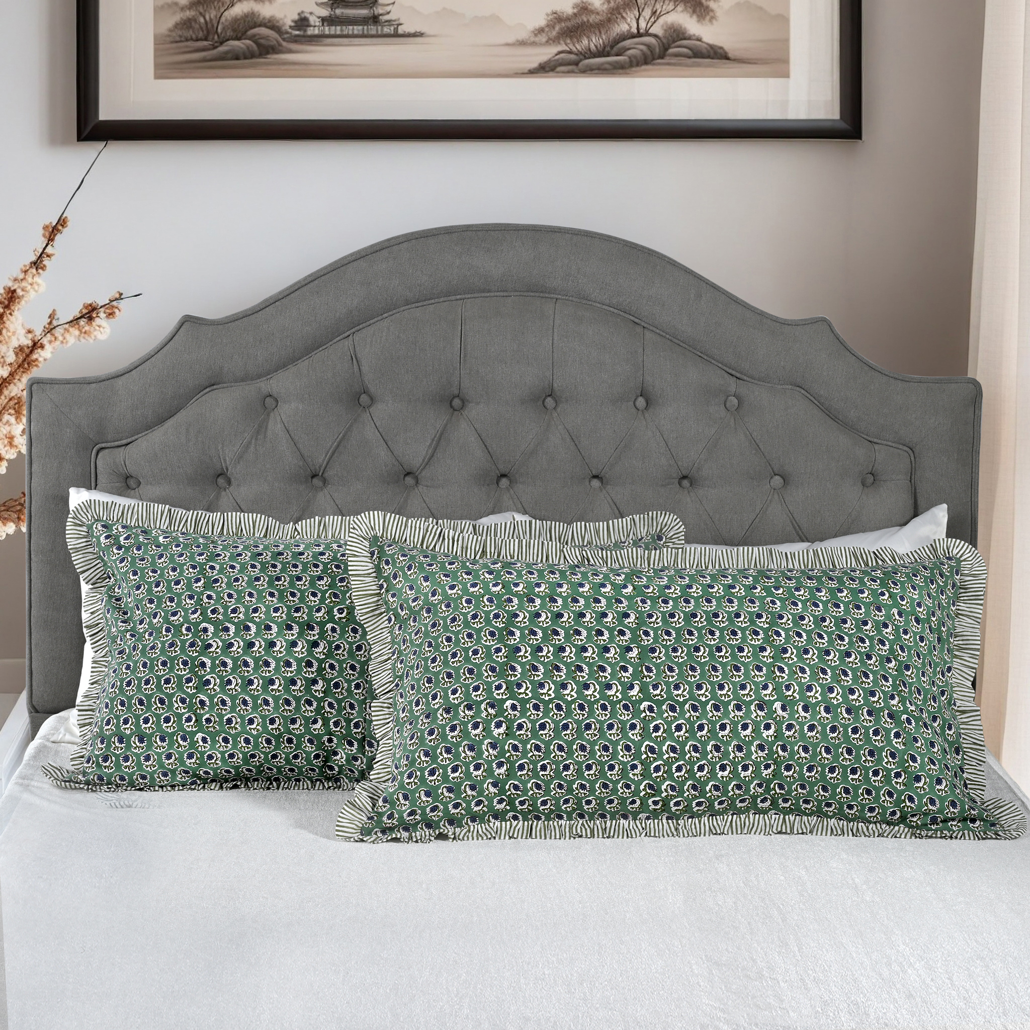 Large block print cotton pillows styled on gray upholstered bed.
