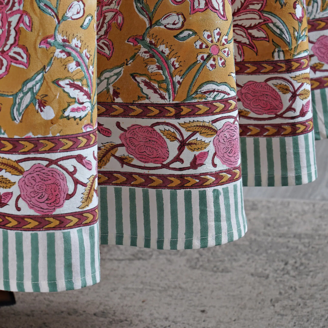 Close-up of patterned fabric with floral and striped designs on a textured surface.