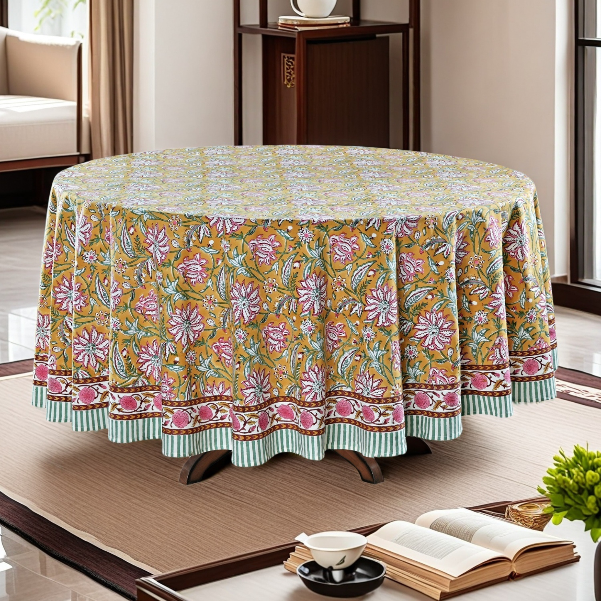 Floral patterned tablecloth on a round table in a room with a book and bowl on a surface.