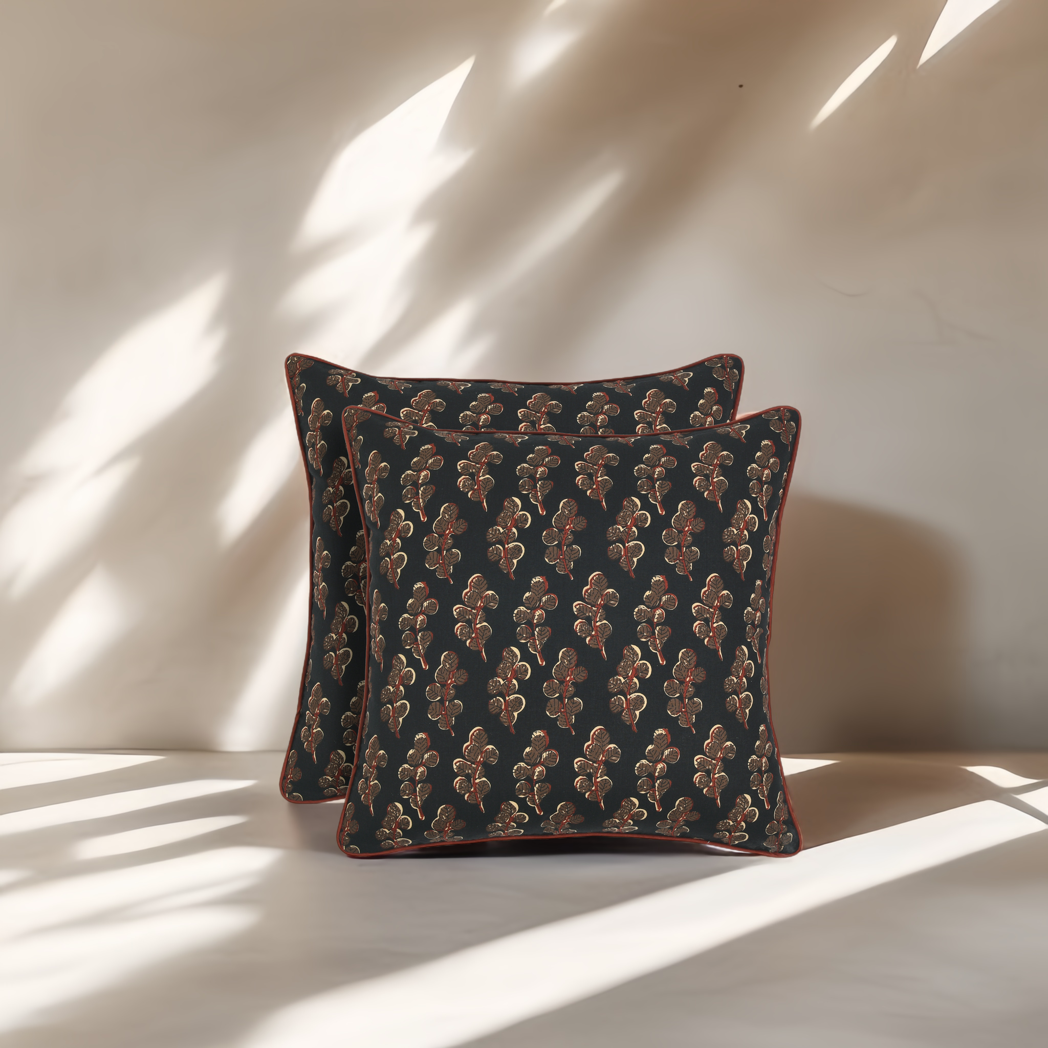 Two patterned cushions on a light surface with soft shadows
