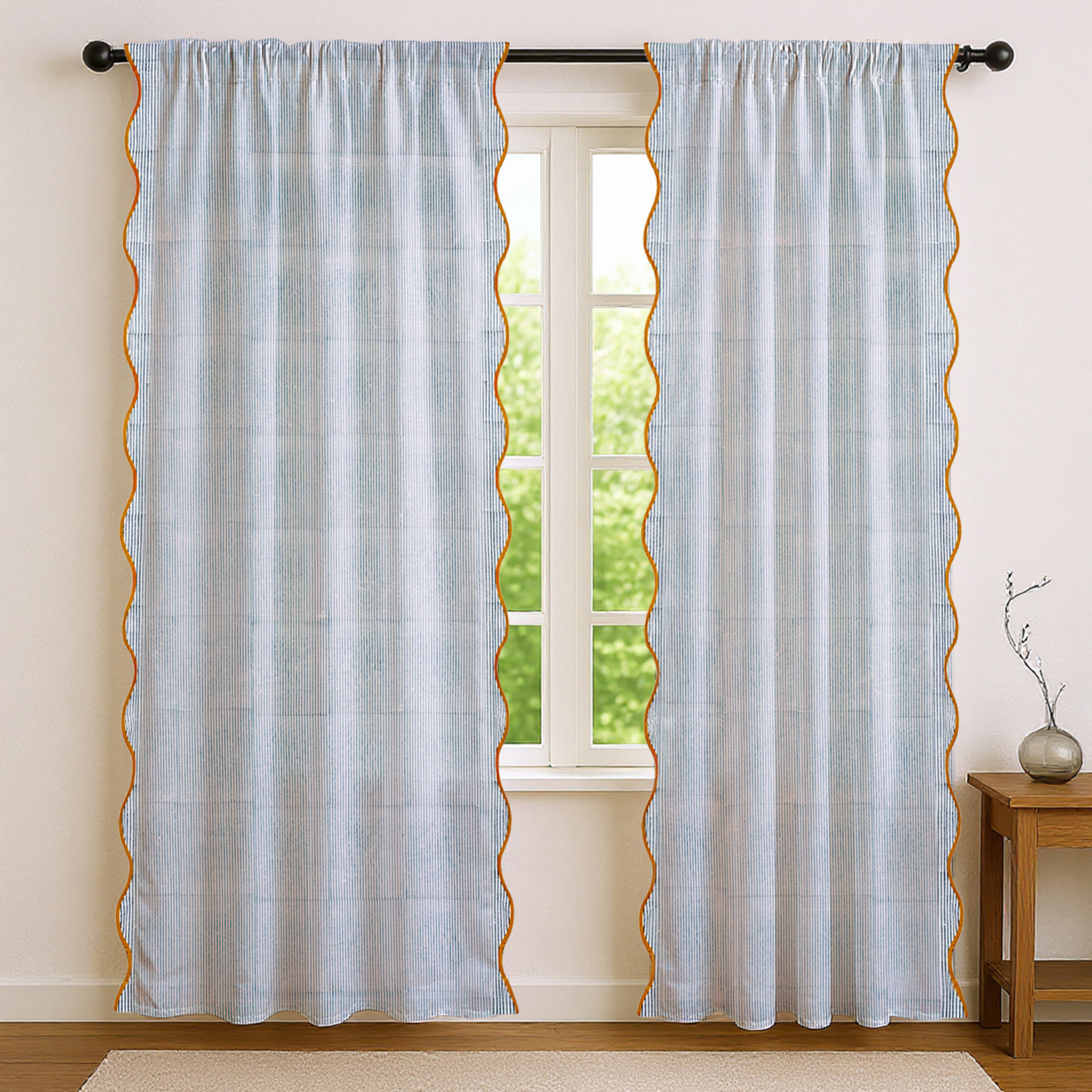 Light blue curtains with scalloped edges hanging in front of a window.