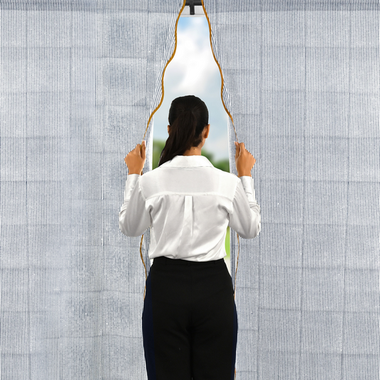 Person holding a unique mirror with a geometric design against a textured wall.