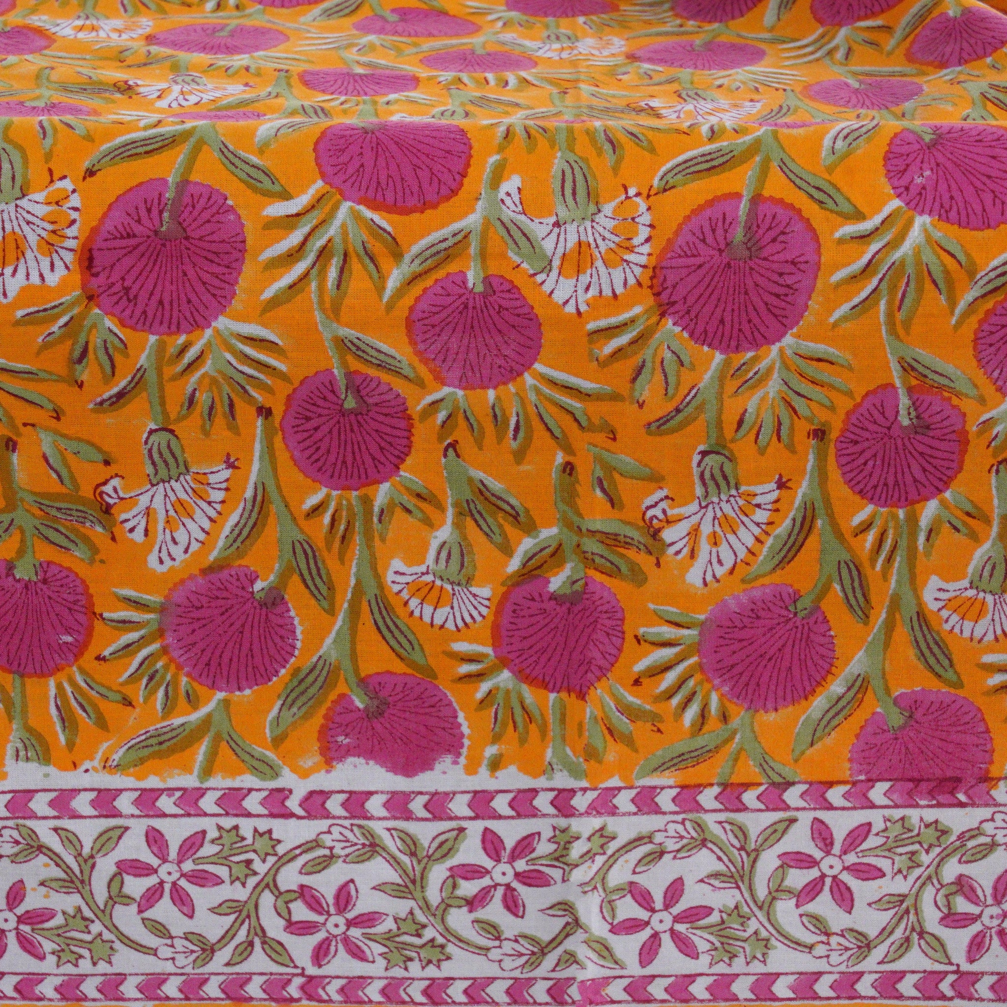 Decorative fabric with pink floral pattern on orange background