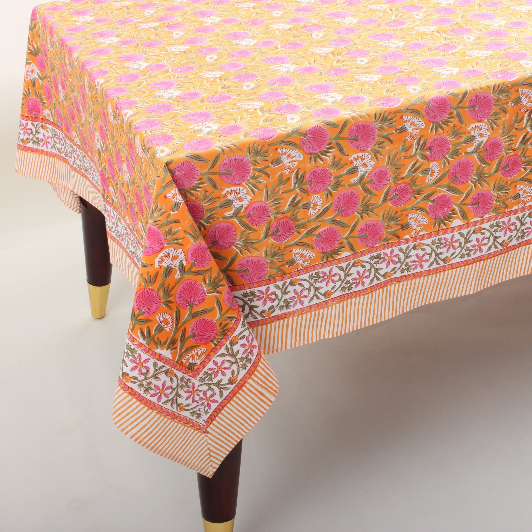 Floral patterned tablecloth on a wooden table with a plain background