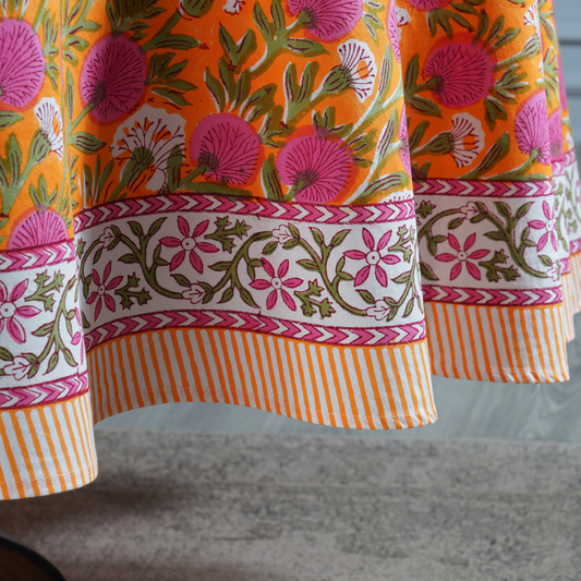 Close-up of a colorful fabric with floral patterns on an orange background.