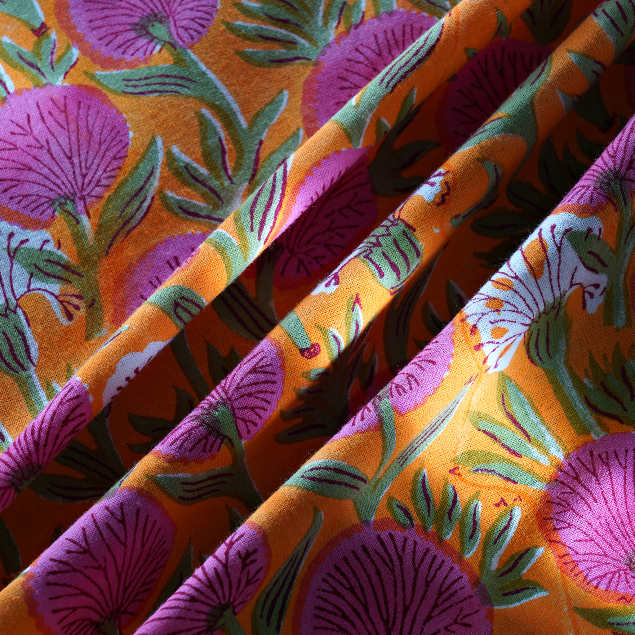 Close-up of colorful fabric with floral pattern on an orange background