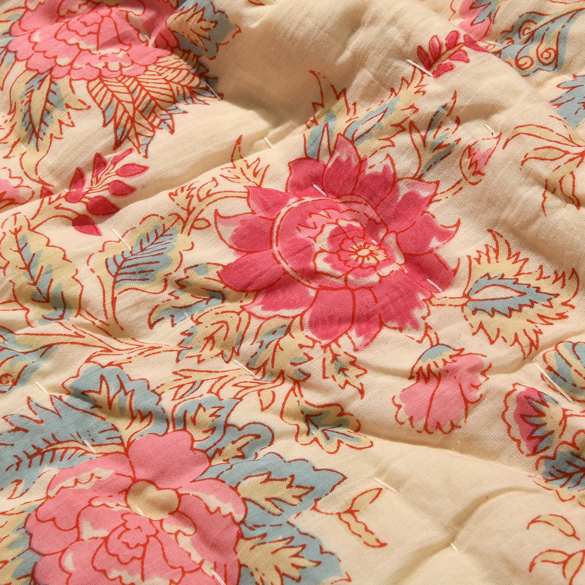 Floral patterned fabric with pink and blue flowers on a beige background