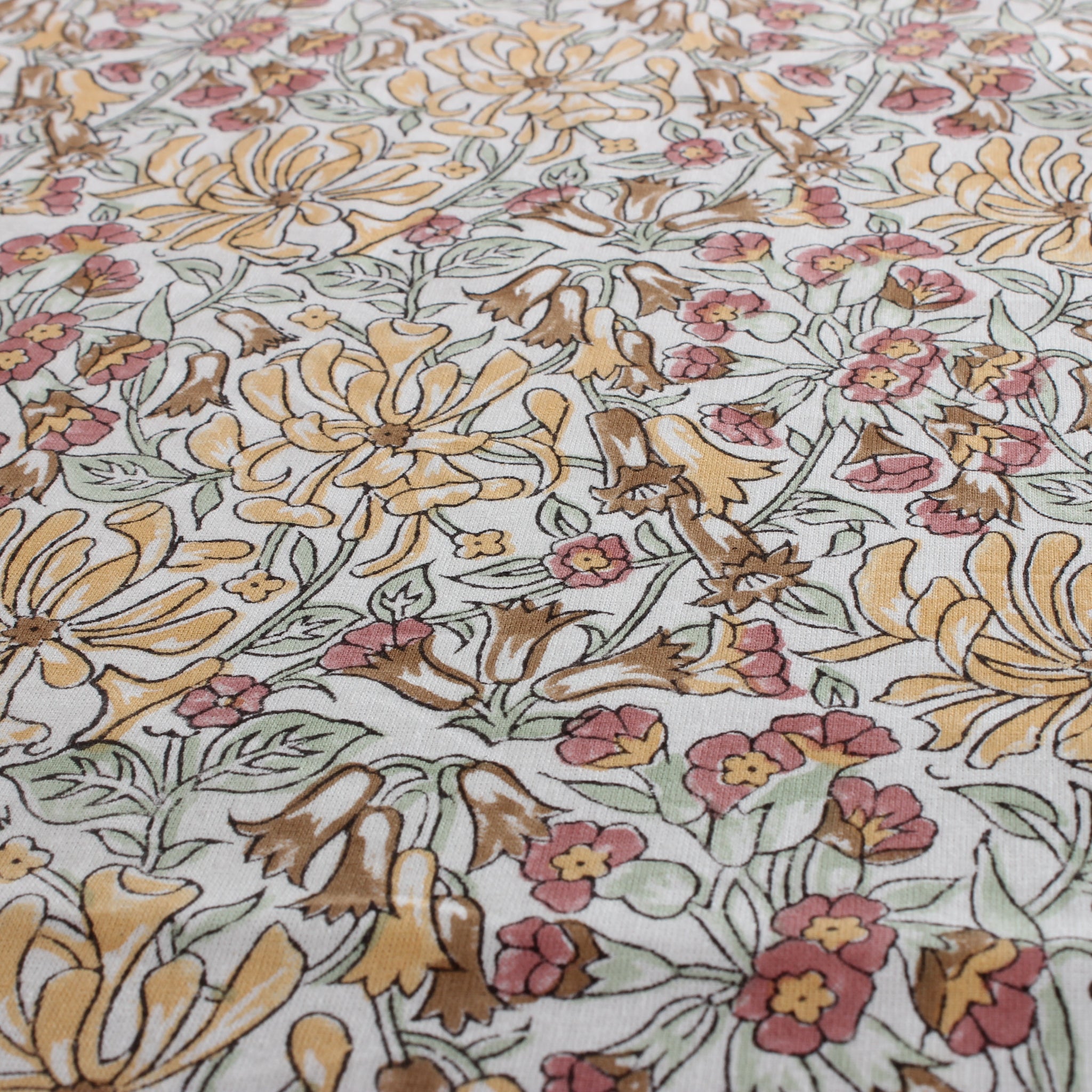 Floral patterned fabric with yellow, pink, and brown flowers on a white background