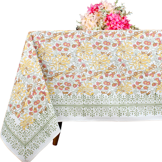 Floral patterned tablecloth on a table with flowers in the background