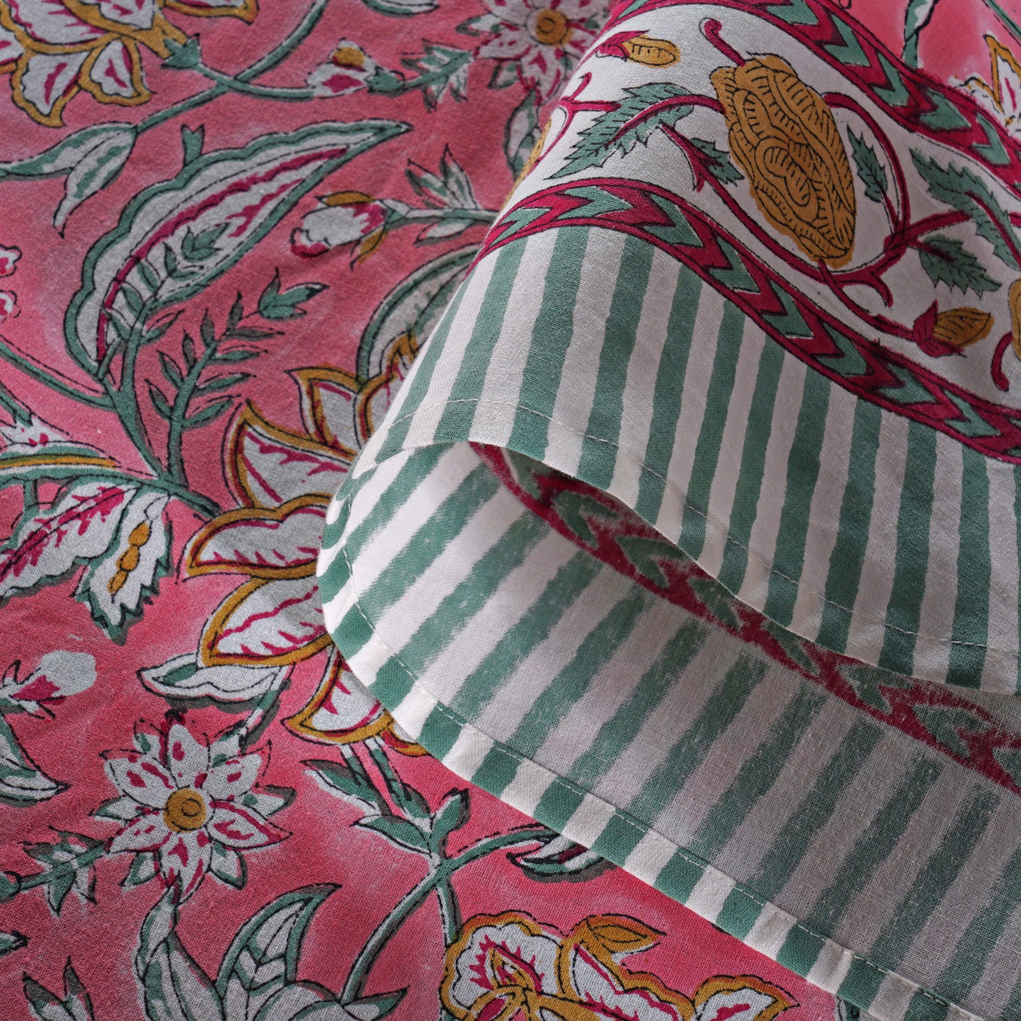 Close-up of fabric with pink floral and green striped patterns