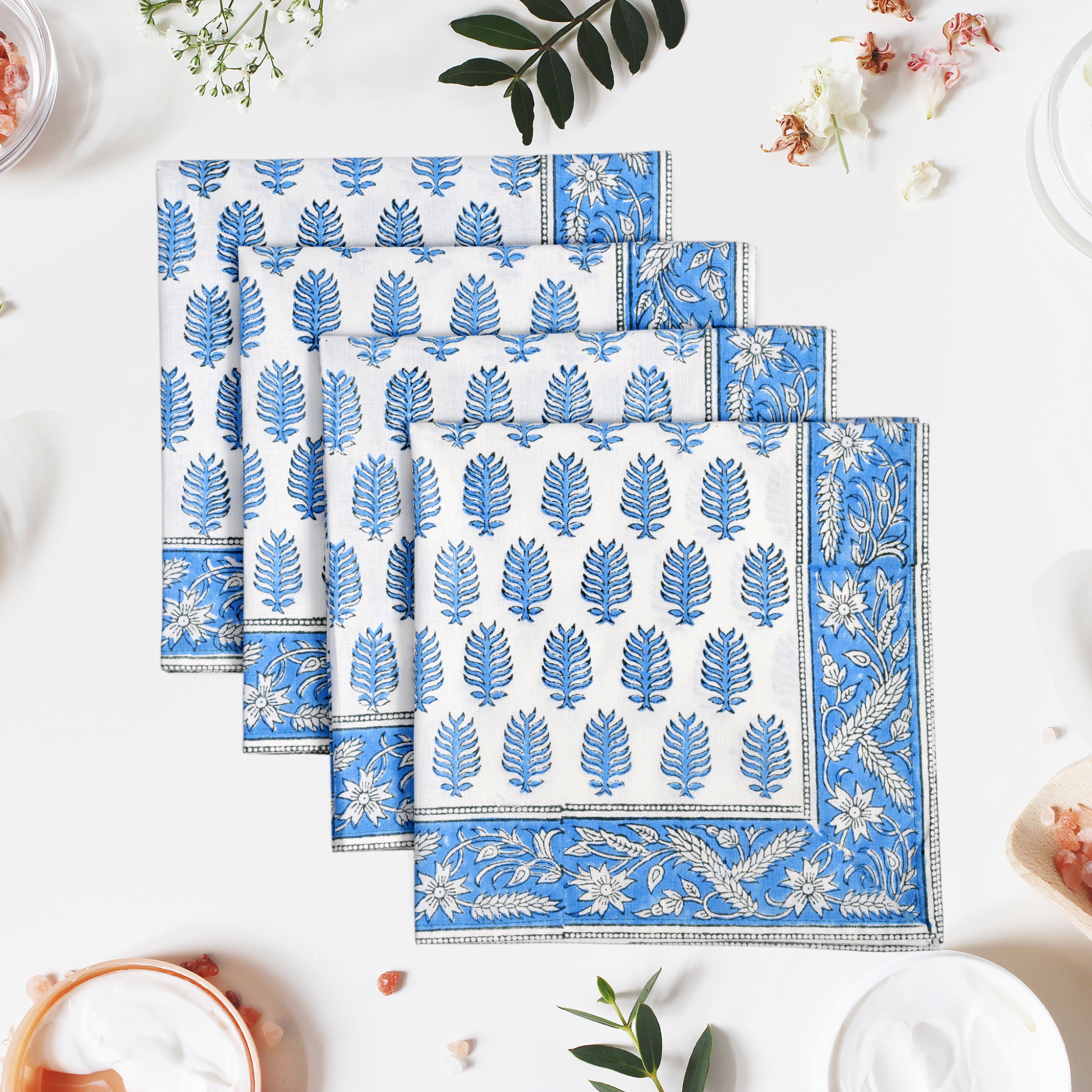 Set of blue and white patterned placemats on a light surface with decorative elements.