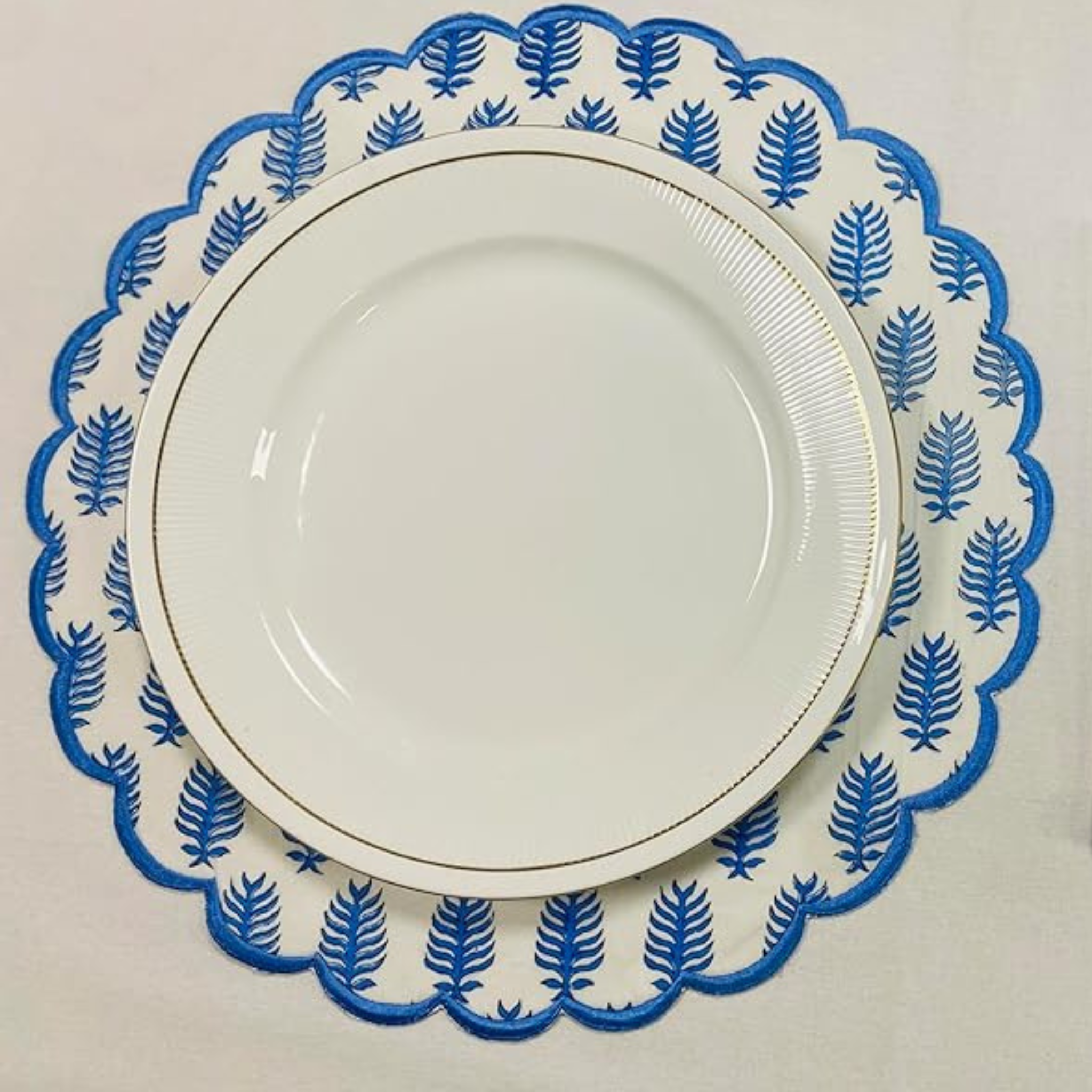 White plate with blue leaf pattern on a white background