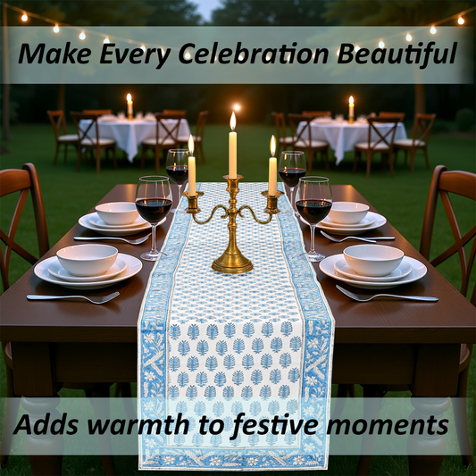 Dining table set for a celebration with a decorative table runner, candles, and wine glasses.