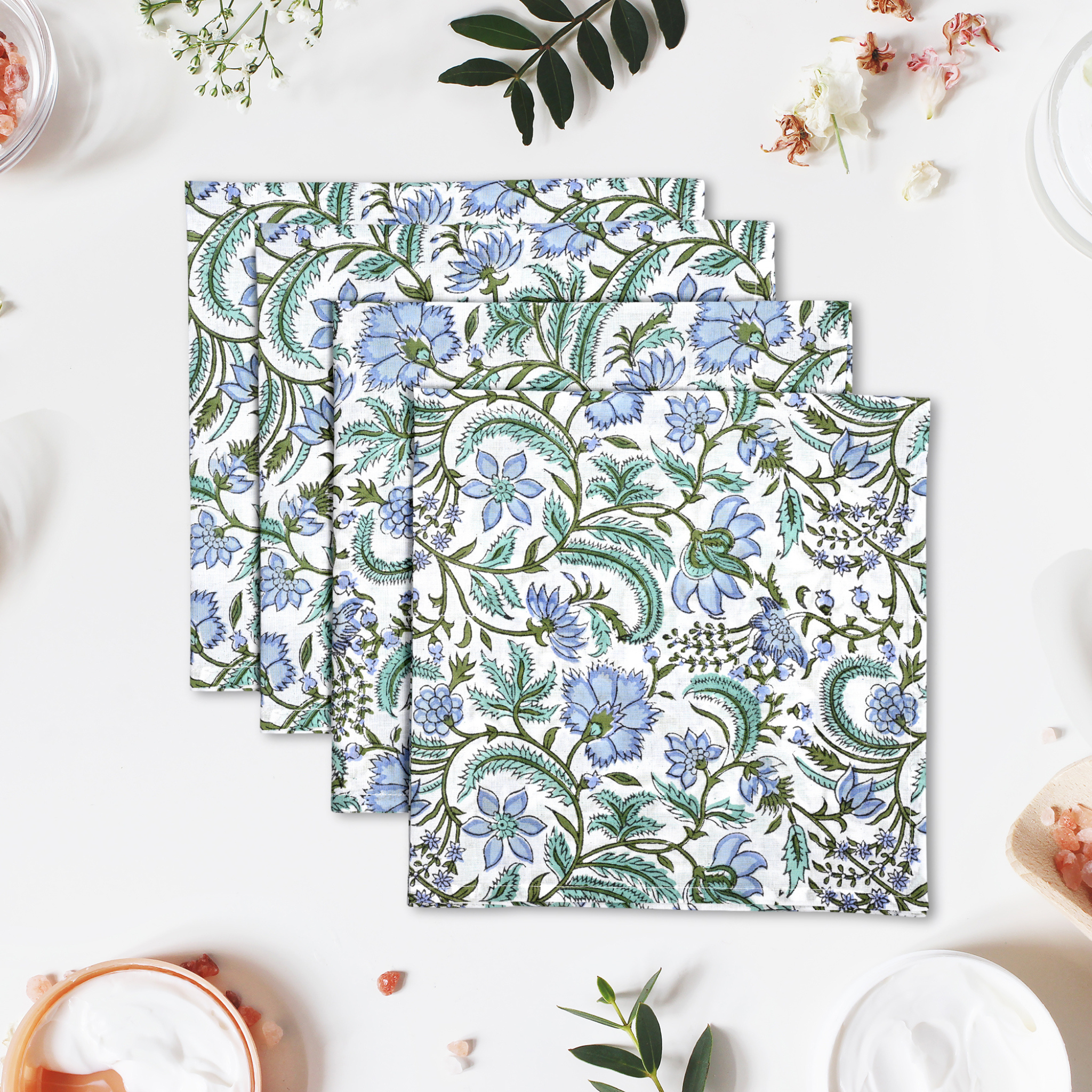Set of floral-patterned napkins on a white surface with decorative elements.