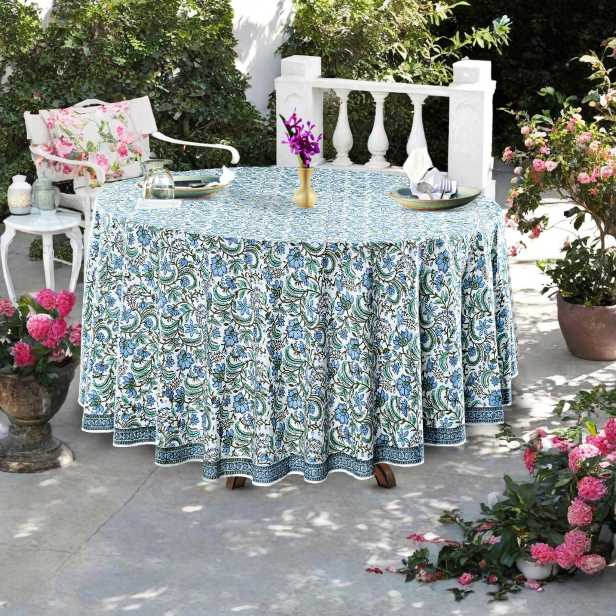 Decorative tablecloth with floral pattern on a round table outdoors.
