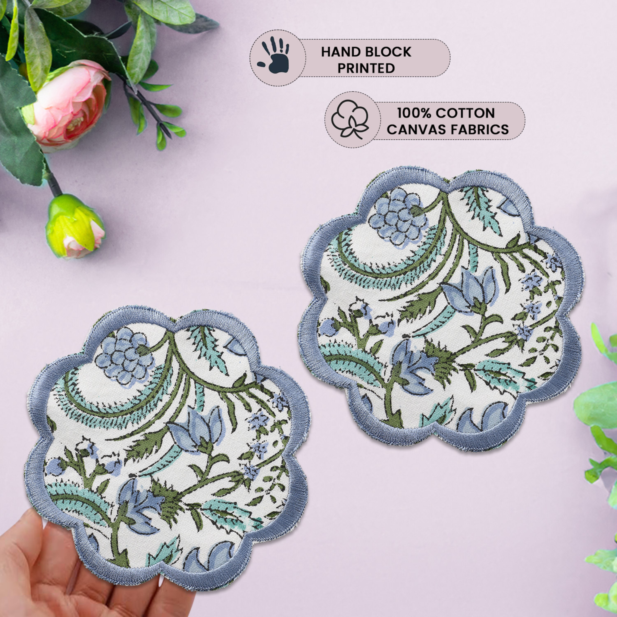 Two floral fabric patches with scalloped edges on a light pink background.