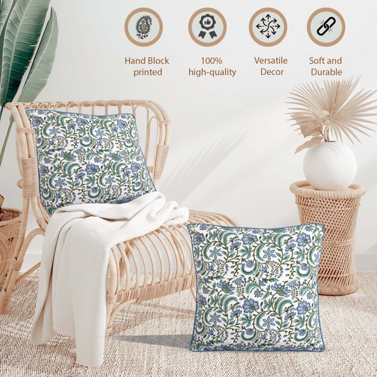 Decorative pillows with floral patterns on a wicker chair, surrounded by plants and decor items.