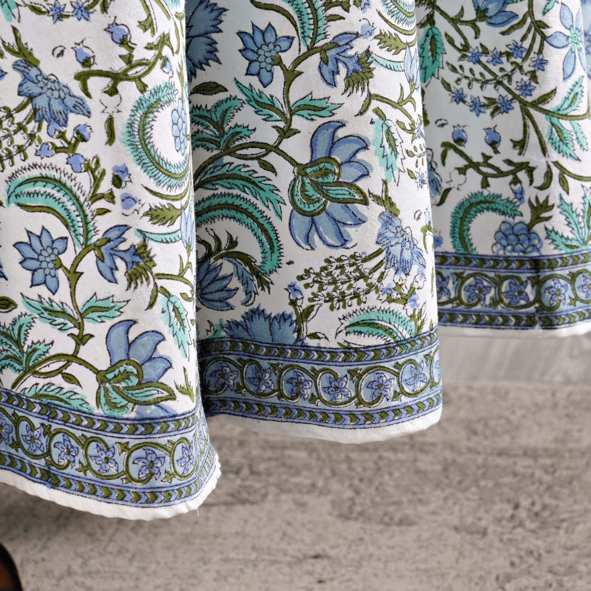 Close-up of floral patterned fabric with blue and green colors on a neutral background