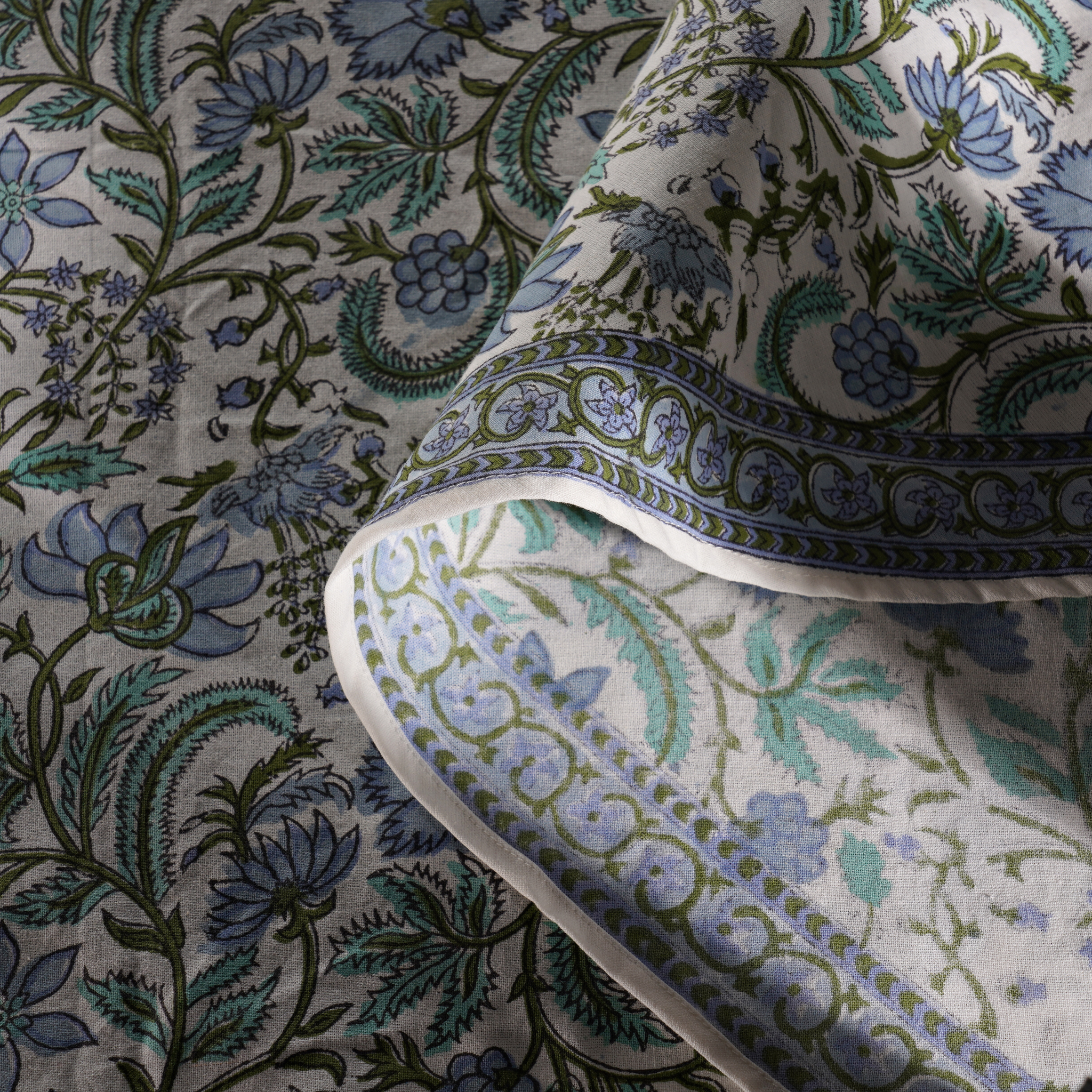 Close-up of floral patterned fabric with blue and green colors.