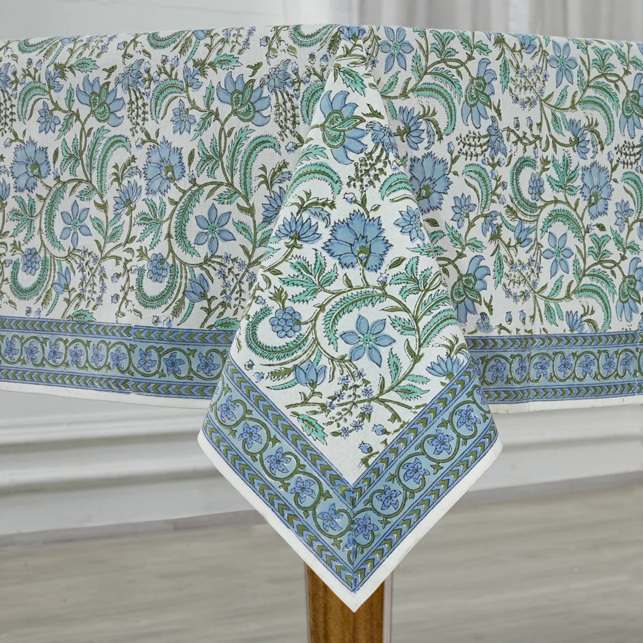 Floral patterned tablecloth on a wooden table with a neutral background