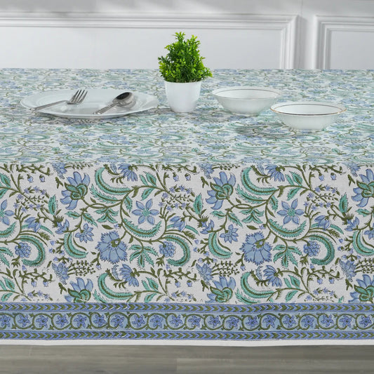 Decorative tablecloth with floral pattern on a set dining table.