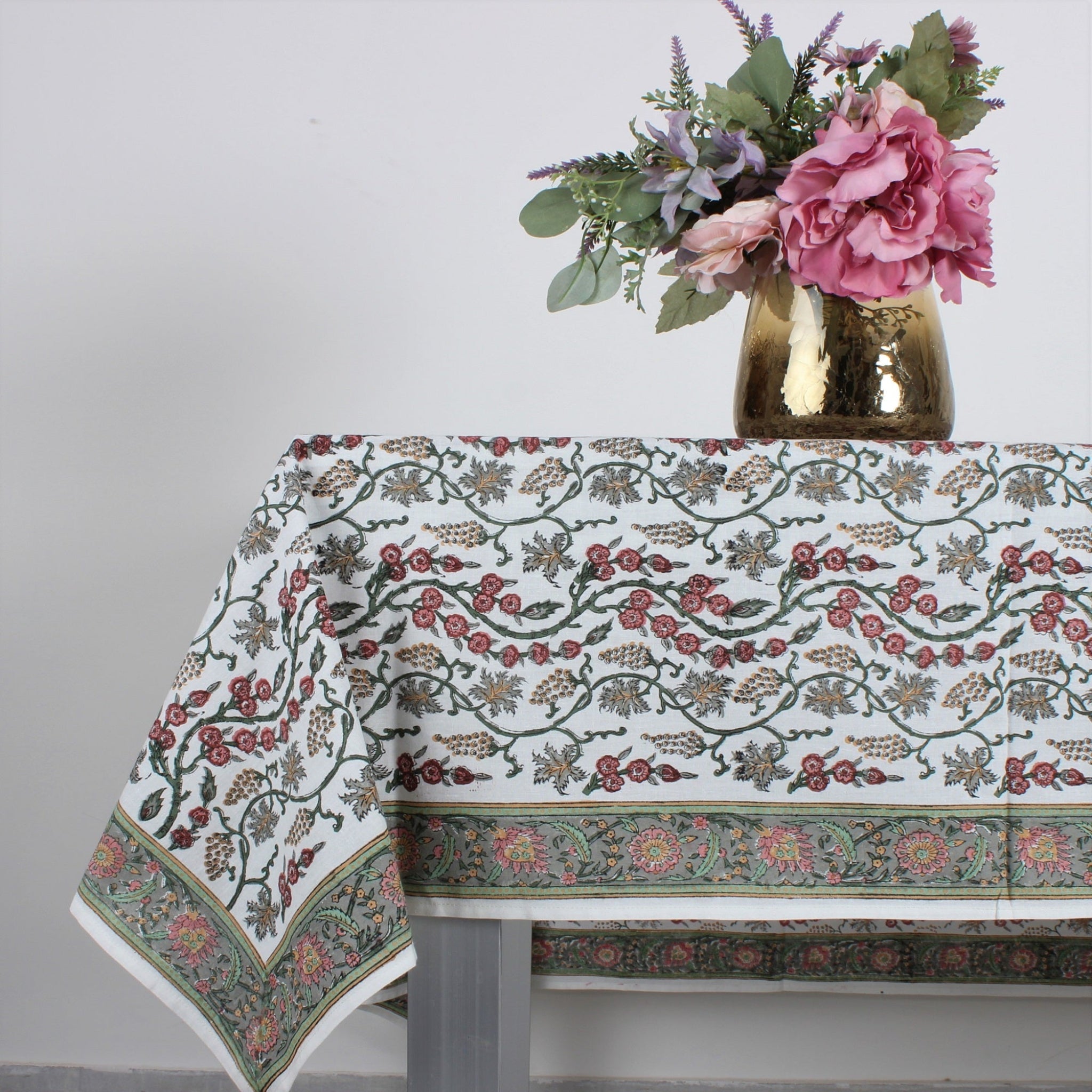 Floral tablecloth with a vase of flowers on a white background