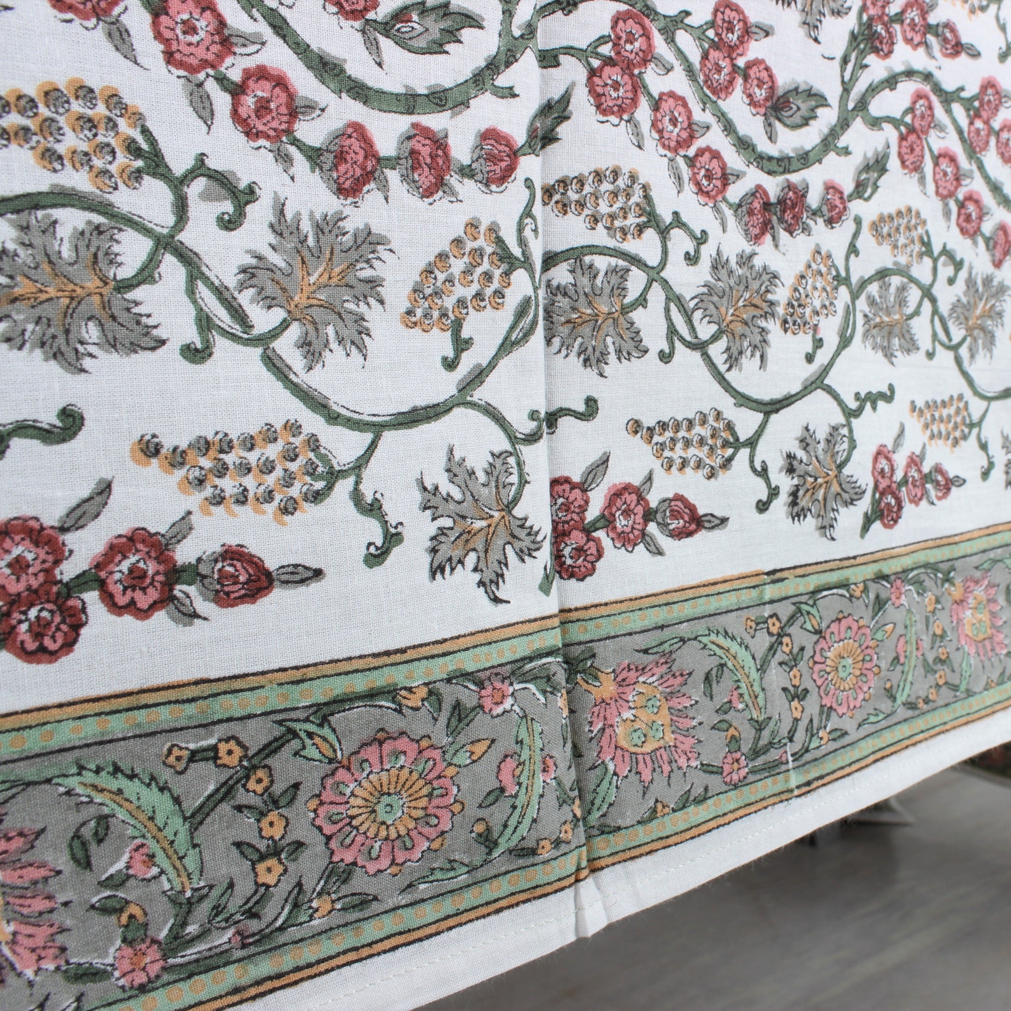 Decorative tablecloth with floral and leaf patterns on a white background