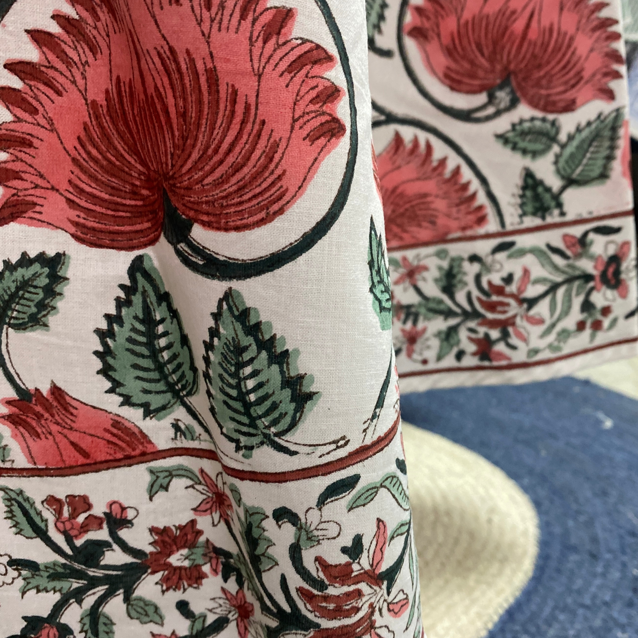 Close-up of a floral patterned fabric with red, green, and black colors.