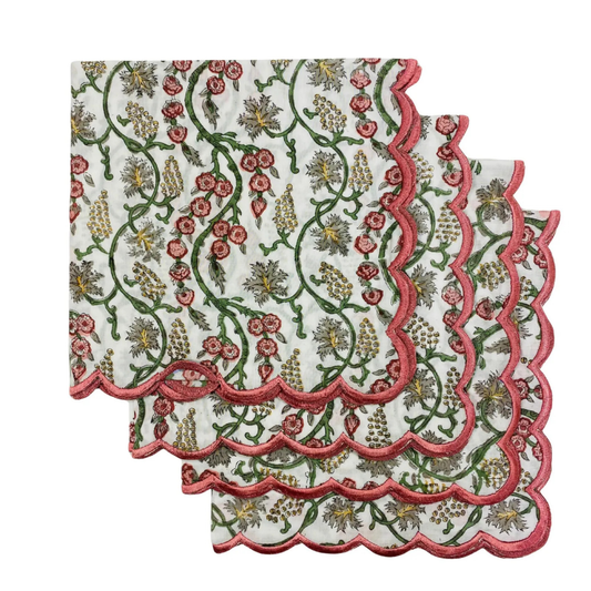 Set of floral patterned napkins with scalloped edges on a white background